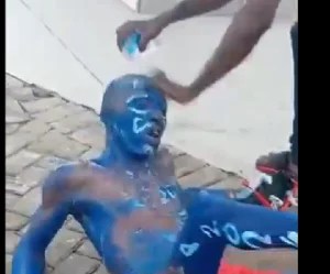 Watch as an angry youth forces a man who painted himself with NPP colours to allegedly beg for money to wash off the paint