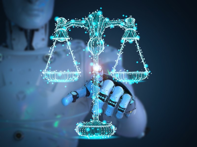 A robot reaches out to touch a digital representation of the justice scales.